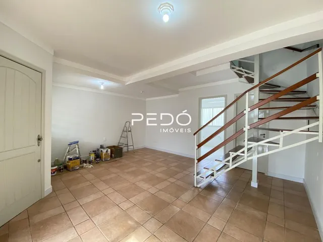 Foto de um corredor interno com piso de cerâmica e escada em um imóvel.