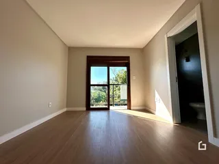 Ambiente interno com piso de madeira e porta de vidro abrindo para o exterior.