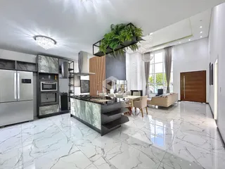Ambiente moderno de sala de estar e cozinha com piso de mármore claro.