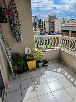 Varanda com piso de cerâmica e plantas decorativas.