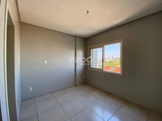 Ambiente interno de uma sala com piso de cerâmica e janela com vista.