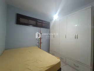 Quarto com cama e armários brancos.