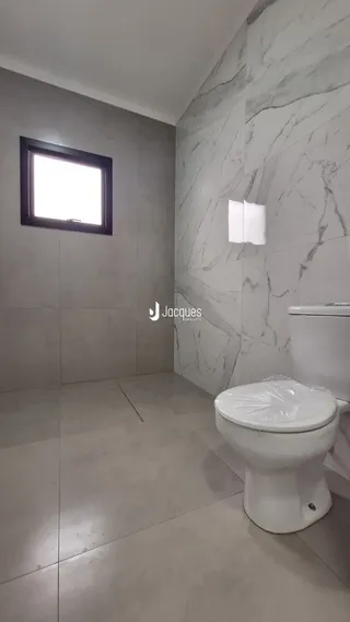 Foto de um banheiro com paredes em mármore e piso de cerâmica.