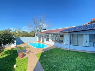 Fachada da casa com piscina e jardim em Lajeado.