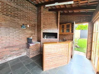 Parede de tijolos aparentes e piso cerâmico em uma área interna.