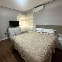 Quarto com cama e ar-condicionado instalado na parede.