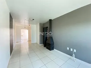 Hall de entrada com piso de cerâmica claro e paredes brancas.
