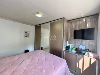 Quarto com cama e painel de madeira na sala.