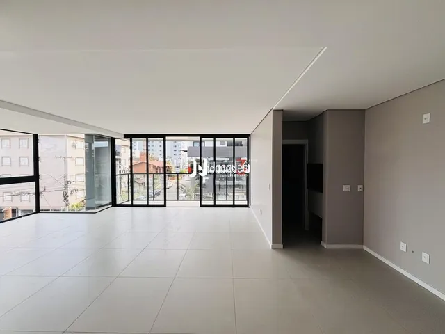Ambiente interno com piso claro e portas de vidro grandes.