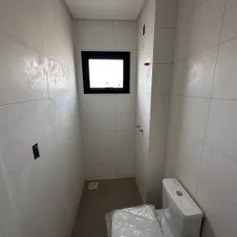 Foto de um banheiro com revestimento de azulejos brancos.