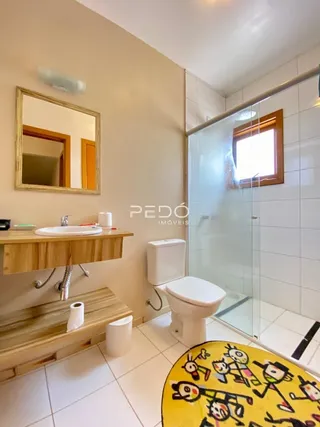 Foto de um banheiro com box de vidro e piso cerâmico.