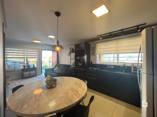 Sala de estar com mesa de jantar e cozinha em um imóvel no Brasil.