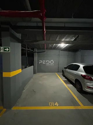 Foto de uma área de concreto com marcações no chão de um imóvel.