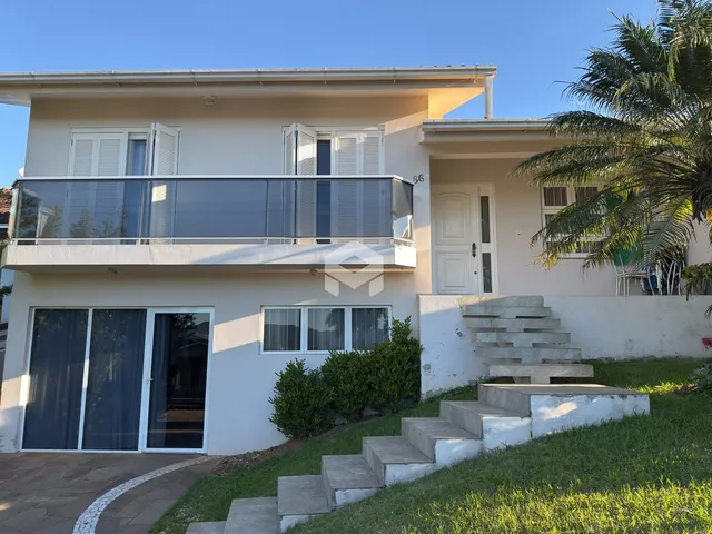 Fachada de uma casa em Lajeado, Brasil com varanda e escadaria externa.