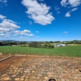 Vista panorâmica de um campo aberto sob um céu azul com nuvens.