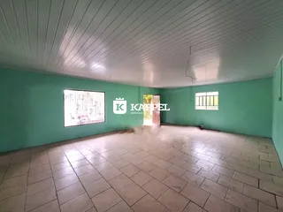 Foto de um ambiente interno amplo com piso de cerâmica e paredes verde-água.