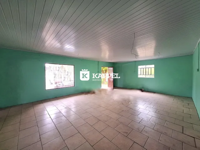 Foto de um ambiente interno amplo com piso de cerâmica e paredes verde-água.