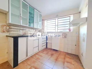 Foto de uma cozinha com armários brancos e piso de cerâmica.