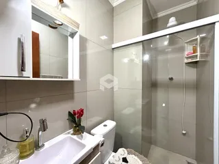 Foto de um banheiro com revestimento de cerâmica e box de vidro.