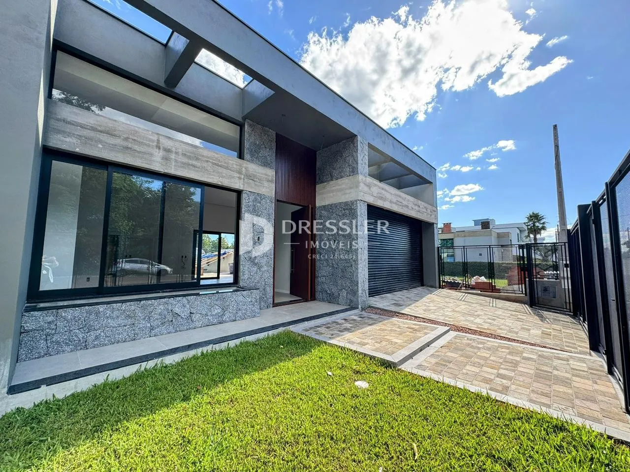 Fachada moderna de uma residência com jardim e área externa em Lajeado.