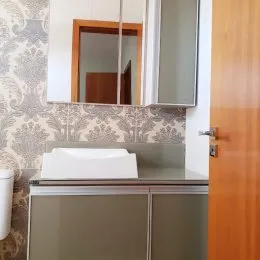 Vista de uma bancada com pia e armários em uma cozinha.