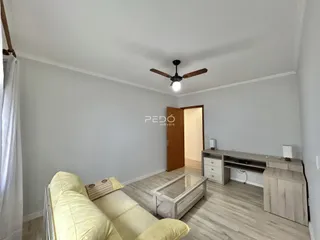 Sala de estar com sofá e piso claro em um imóvel no Brasil.