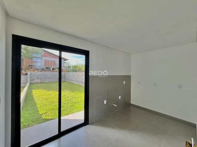 Vista da sala de estar com porta de vidro para o jardim.