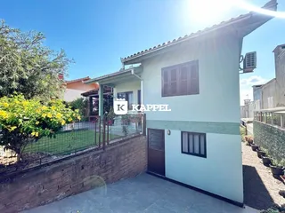 Fachada de uma casa em Lajeado, Brasil, com paredes claras e telhado de telhas.