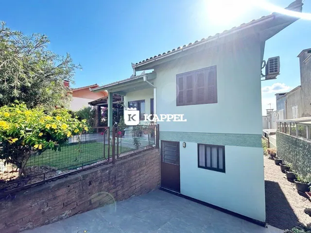 Fachada de uma casa em Lajeado, Brasil, com paredes claras e telhado de telhas.