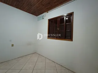 Vista interna de um ambiente com piso de cerâmica e teto de madeira.