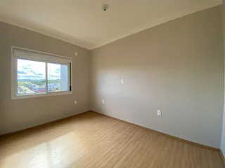 Sala de estar com piso de madeira e janela com vista para a paisagem externa.