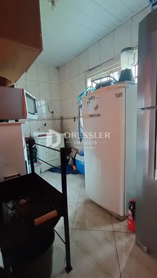 Foto do interior de uma cozinha com revestimento de cerâmica e eletrodomésticos.