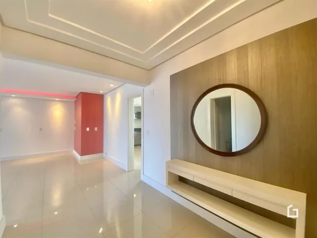 Hall de entrada com paredes brancas e detalhes em madeira.