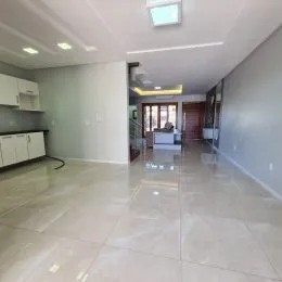 Ambiente interno com piso claro e paredes brancas em uma área comum.