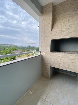 Parede interna com vista para a paisagem através de uma grande janela.