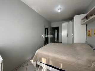 Quarto com cama grande e armários em um ambiente claro.
