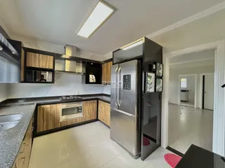 Foto de uma cozinha moderna com armários escuros e eletrodomésticos de aço inoxidável.