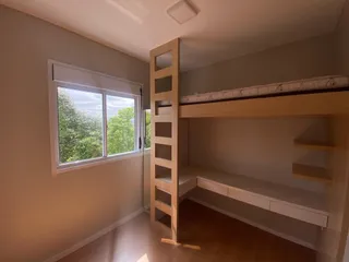 Foto interna de um quarto com janela e estante de madeira.
