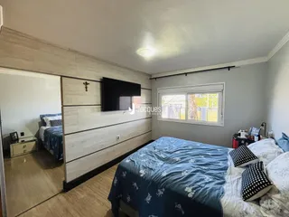 Quarto com cama e painel de madeira na parede.