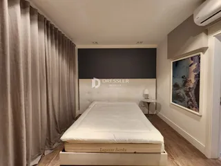 Quarto com cama e cortinas longas.