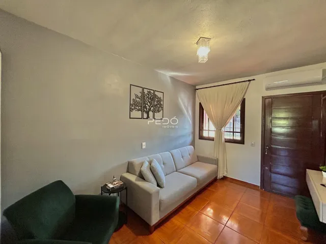Sala de estar com sofá e piso de madeira em um imóvel no Brasil.