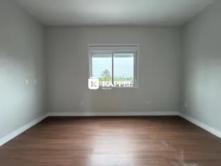 Uma sala de estar com piso de madeira e uma janela grande.