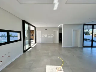 Sala de estar ampla com piso de cerâmica e portas de vidro.