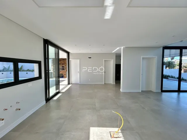 Sala de estar ampla com piso de cerâmica e portas de vidro.