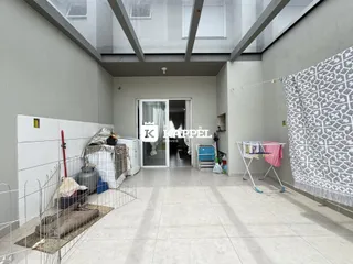 Hall de entrada com piso de concreto e estrutura de teto exposta.
