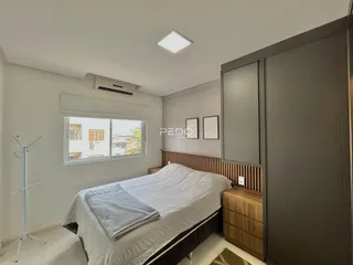 Quarto com cama e janela de vista para a cidade.