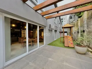 Fachada de uma residência com portas de vidro abrindo para uma área externa gramada.