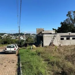 Fachada de um imóvel em Lajeado, Brasil, com vegetação no primeiro plano.