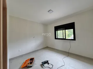Vista interna de um cômodo vazio com paredes brancas e piso claro.
