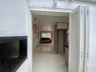Hall de entrada com piso de cerâmica e vista para a sala de estar.